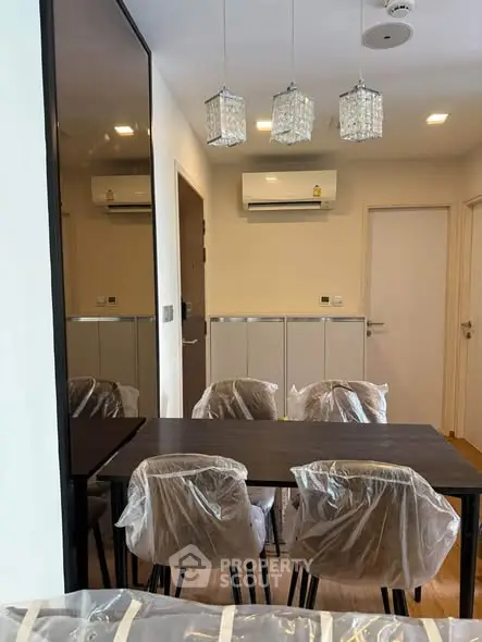 Modern dining area with elegant lighting and air conditioning in a stylish apartment.