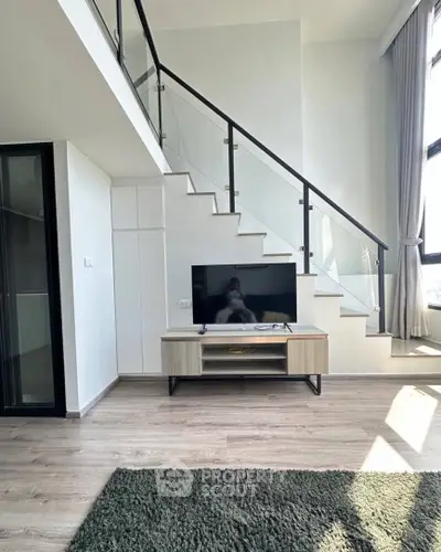 Modern duplex living room with sleek staircase and large windows