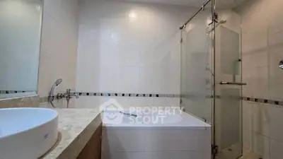 Modern bathroom with sleek bathtub and glass shower enclosure