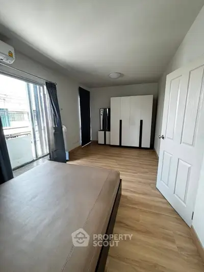 Spacious bedroom with modern furnishings and balcony access in a stylish apartment.