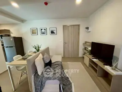 Modern living room with stylish decor and open dining area, featuring a sleek TV setup and contemporary furniture.