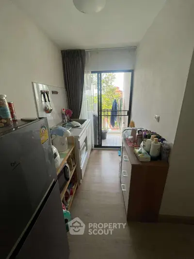 Compact kitchen with balcony view, featuring modern appliances and ample storage space.