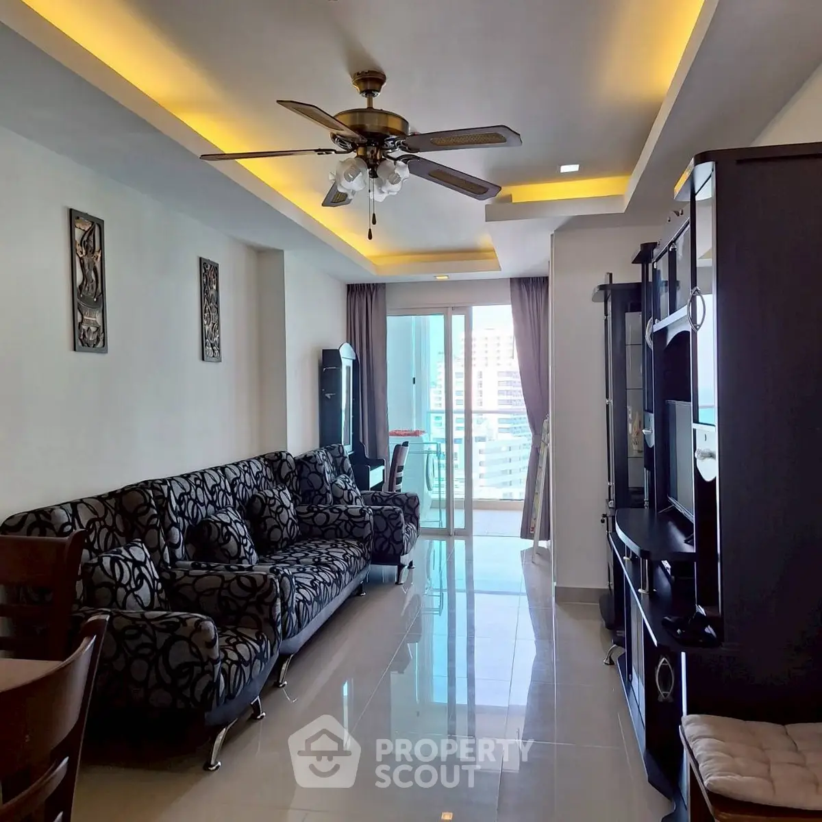 Spacious living room with modern decor and balcony access in a high-rise apartment.