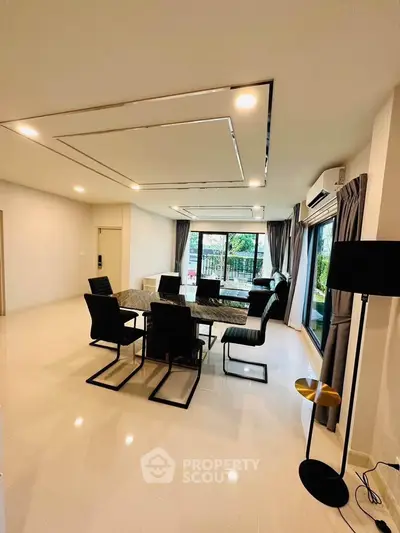 Spacious modern dining room with elegant table and chairs, large windows, and stylish lighting.