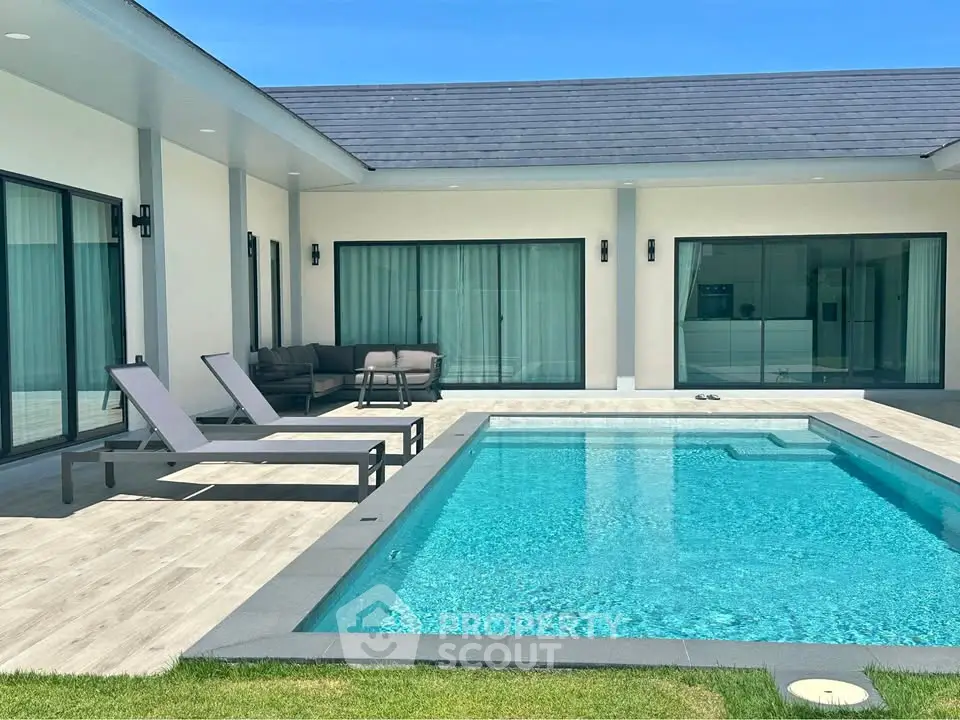 Luxurious modern home with private pool and stylish outdoor seating area, perfect for relaxation and entertainment.
