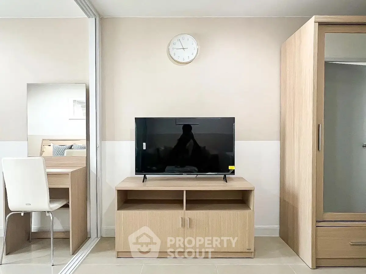 Modern living room with sleek TV stand and mirrored wardrobe in stylish apartment.
