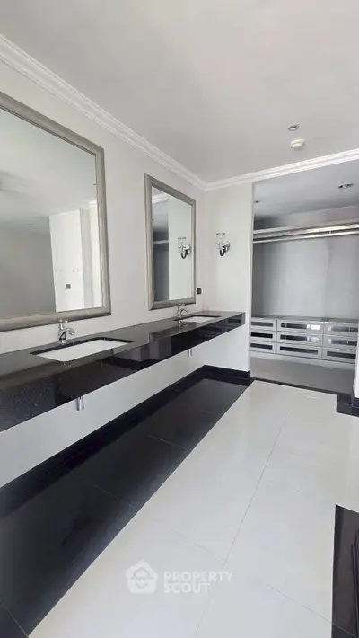 Spacious modern bathroom with dual sinks and large mirrors in luxury home.