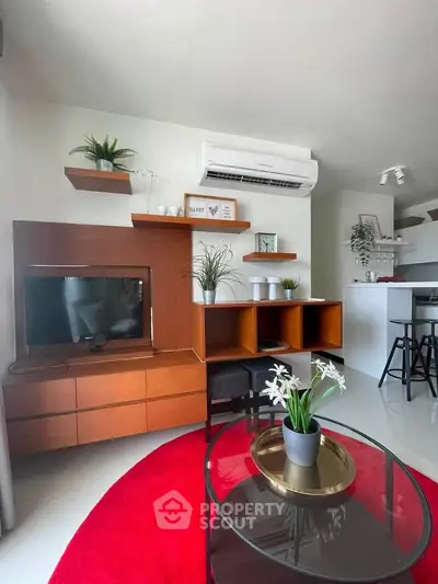 Modern living room with stylish furniture and air conditioning, featuring a cozy red rug and elegant decor.