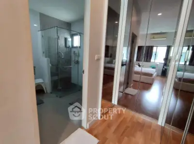 Modern apartment interior with glass shower and mirrored closet doors