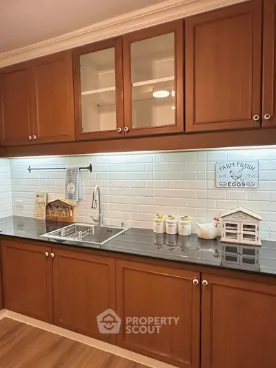 Charming kitchen with wooden cabinets and farmhouse decor, featuring a sleek black countertop and white subway tiles.