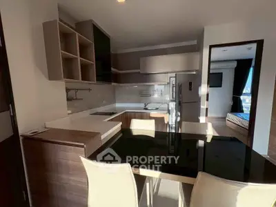 Modern kitchen with sleek design and dining area, featuring open layout and contemporary furniture.