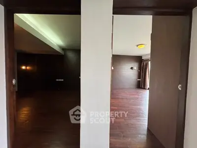 Spacious interior with dark wood flooring and modern lighting, perfect for stylish living.