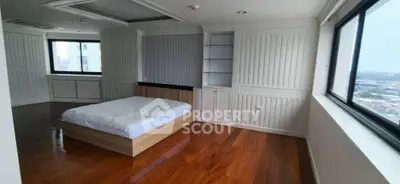 Spacious bedroom with wooden flooring and large windows offering city views