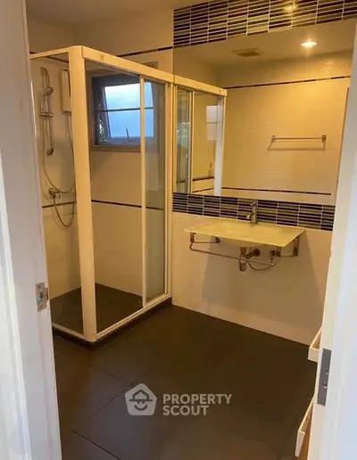 Modern bathroom with sleek shower and stylish sink in contemporary home.