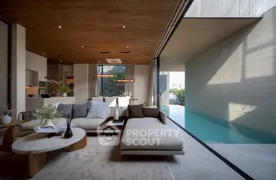 Luxurious modern living room with pool view and open kitchen layout, featuring elegant furniture and wooden ceiling.