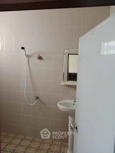 Simple bathroom with shower and sink, ideal for minimalist living.
