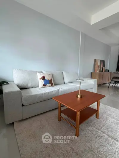 Modern living room with cozy gray sofa and wooden coffee table, perfect for relaxation.
