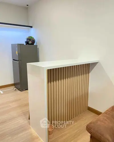 Modern interior with stylish partition and sleek fridge in cozy living space.