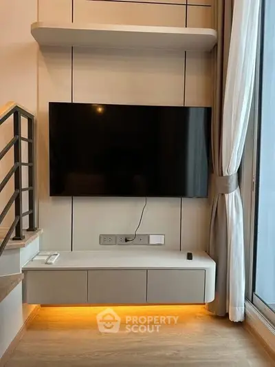 Modern living room with wall-mounted TV and stylish shelving