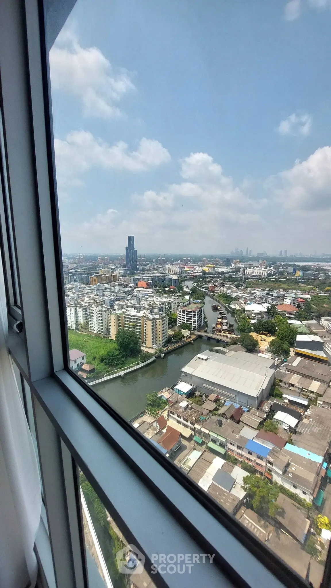 Stunning cityscape view from high-rise window showcasing urban skyline and river.
