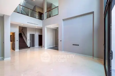 Spacious modern living room with high ceilings and elegant staircase