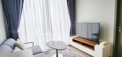 Modern living room with sleek furniture and large window drapes