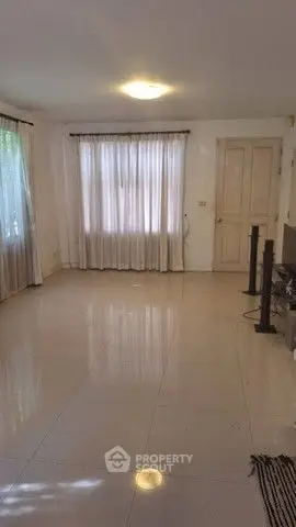 Spacious empty living room with large windows and tiled floor