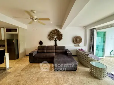 Spacious living room with modern decor and large sofa in open layout apartment.