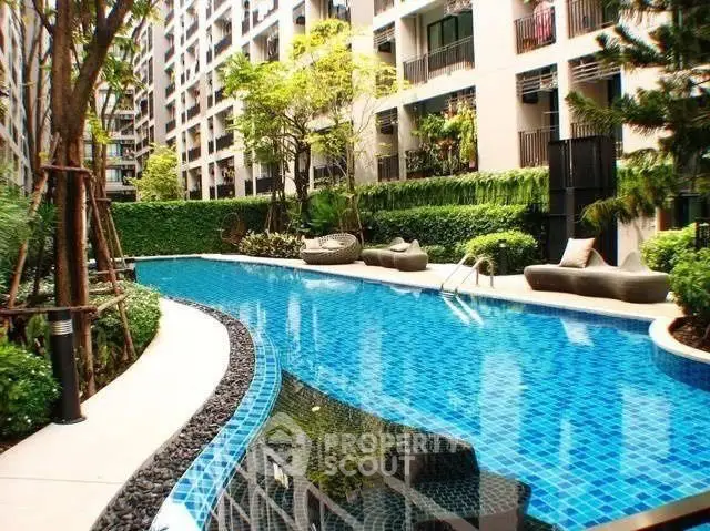 Luxurious residential complex with a stunning outdoor pool surrounded by lush greenery.