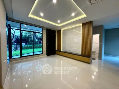 Spacious modern living room with large windows and elegant ceiling lights