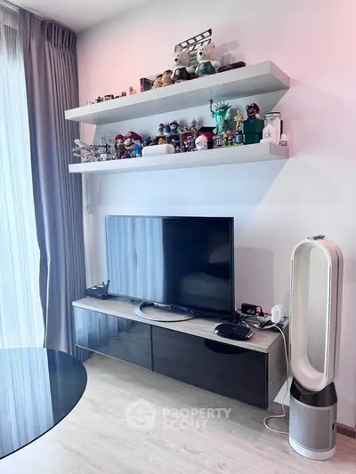 Modern living room with sleek TV setup and stylish shelves displaying collectibles.