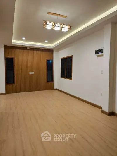 Spacious modern living room with elegant lighting and wooden flooring.