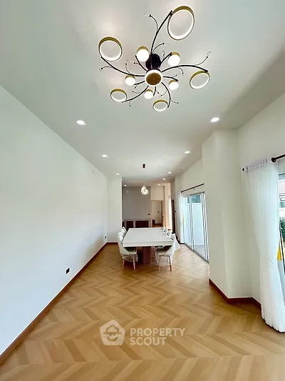 Spacious modern dining area with elegant chandelier and natural light