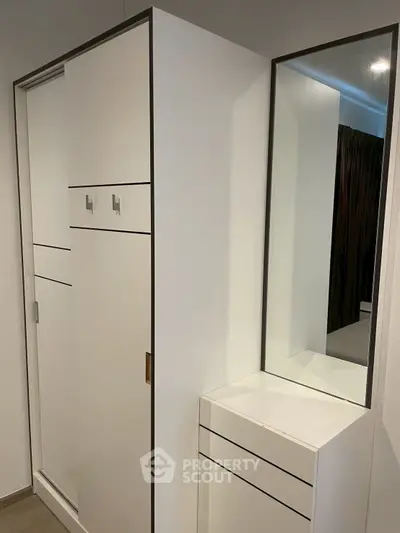 Modern minimalist wardrobe with sleek design and integrated mirror in a stylish interior.