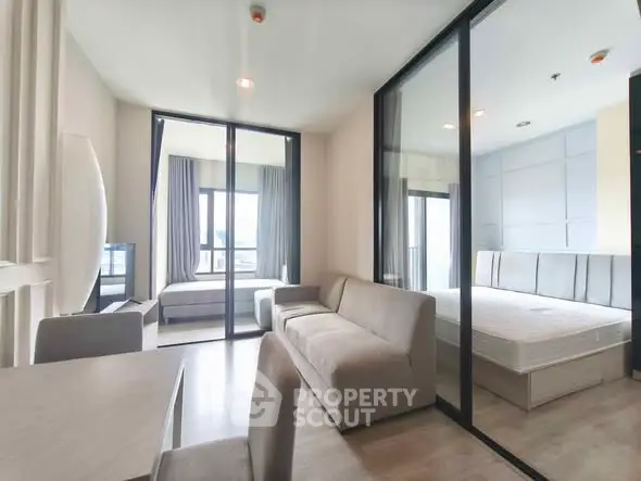 Modern apartment interior with spacious living room and bedroom, featuring large windows and sleek design.