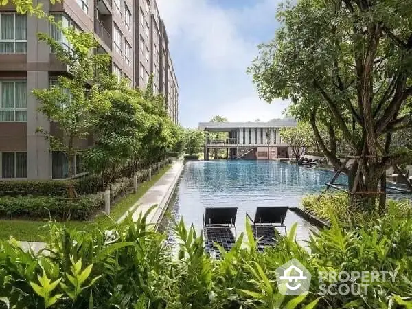 Luxurious apartment complex with serene pool and lush greenery