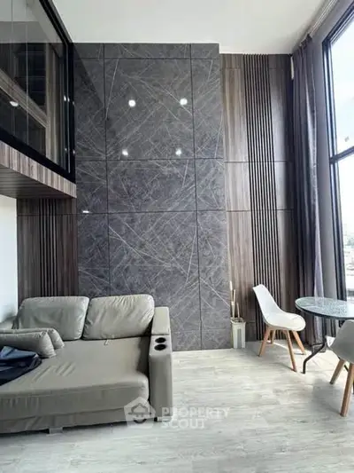 Modern living room with stylish decor and large windows offering natural light