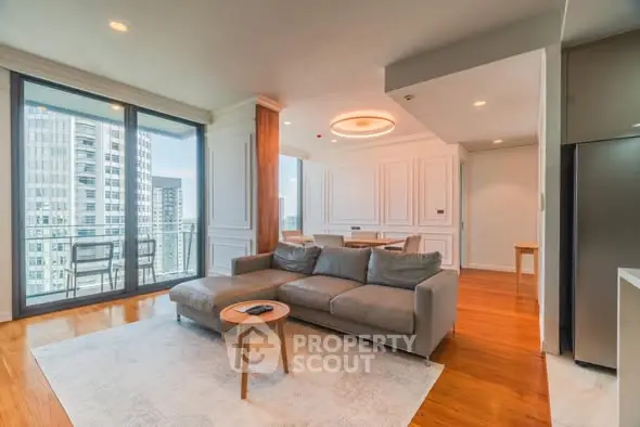Spacious modern living room with large windows and city view, featuring elegant decor and cozy seating.