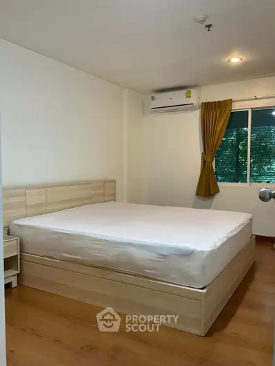 Spacious bedroom with modern wooden bed and air conditioning, perfect for comfort and relaxation.