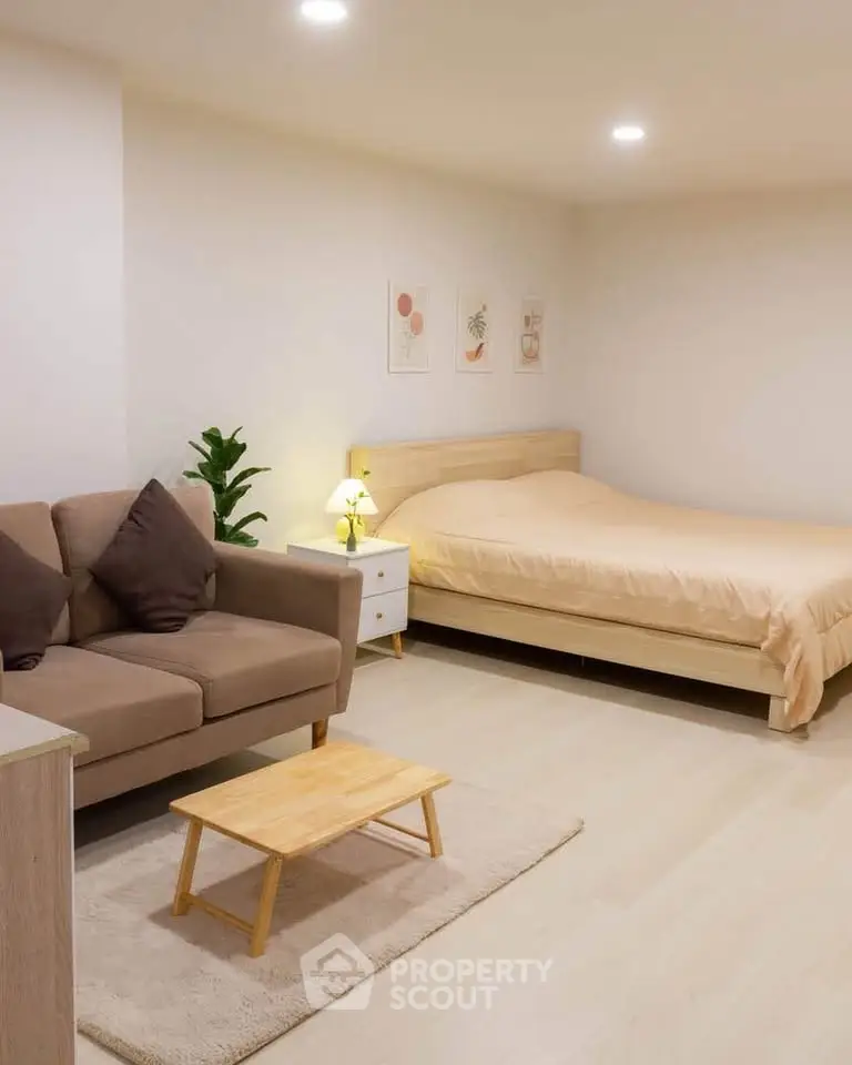 Spacious studio apartment with cozy bed and stylish sofa in modern decor.
