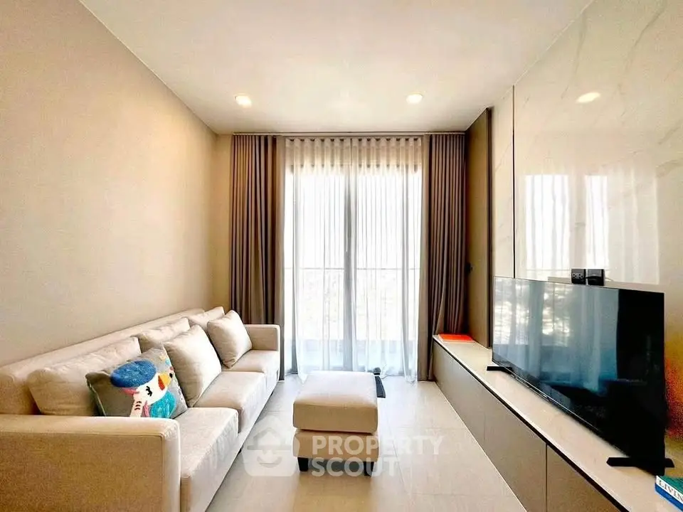 Modern living room with cozy sofa and large TV, perfect for relaxation.