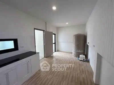 Spacious utility room with modern flooring and ample storage space.