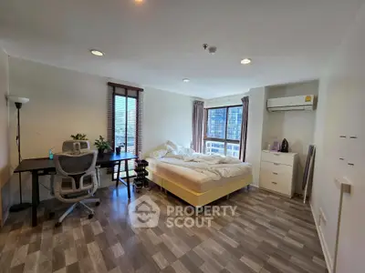 Spacious bedroom with modern decor and city view, featuring a cozy bed and work desk.