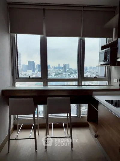 Modern kitchen with city view, featuring sleek countertops and built-in microwave, perfect for urban living.