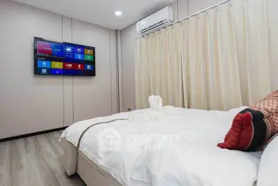 Modern bedroom with wall-mounted TV and elegant decor