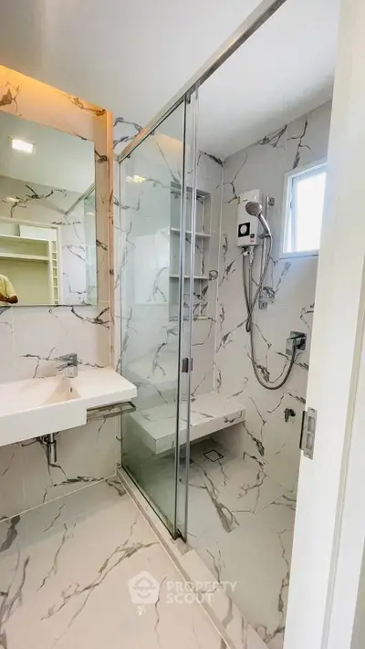Modern bathroom with marble tiles and glass shower enclosure