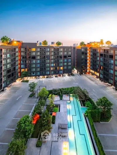 Modern apartment complex with pool and lush greenery, offering urban living with resort-style amenities.