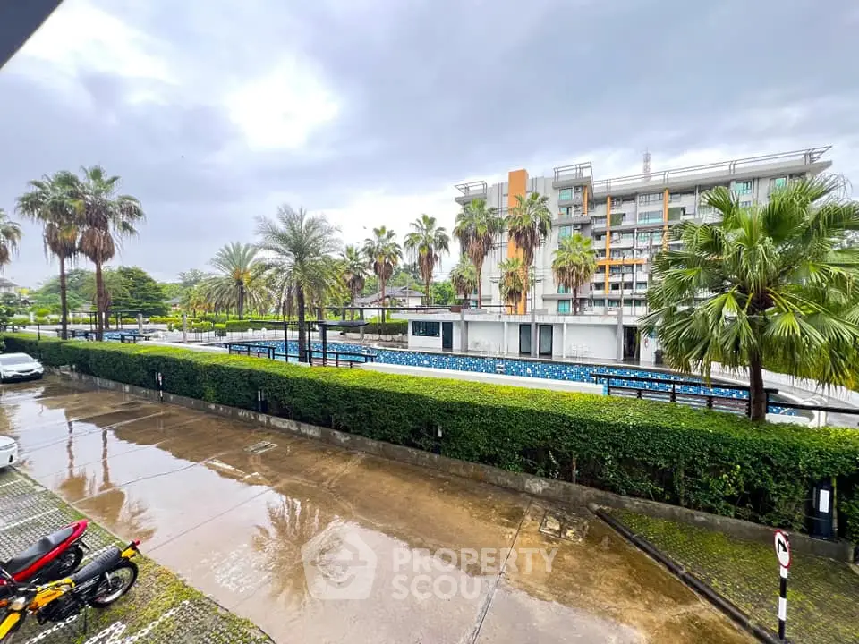 Modern residential building with pool and lush palm trees
