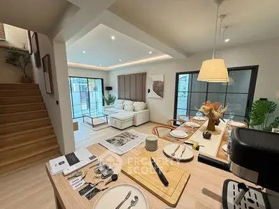 Modern open-plan living room with stylish decor and natural light, featuring a cozy seating area and dining space.