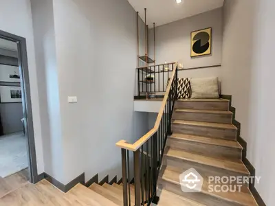 Stylish modern staircase with wooden steps and elegant railing in a contemporary home interior.